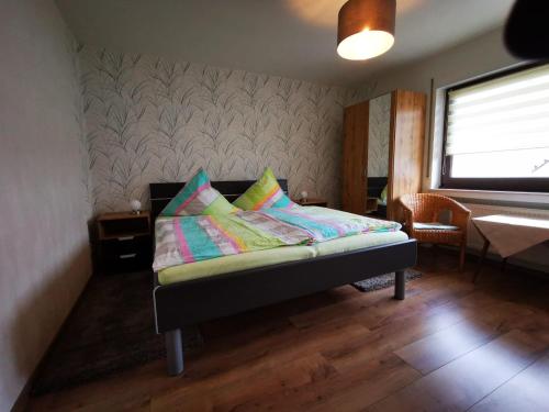 a bedroom with a bed with colorful pillows on it at Gästehaus Andrea Blatt in Bruttig-Fankel