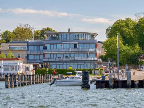 un bateau amarré devant un grand bâtiment dans l'établissement Haus Putbus - Ferienwohnung 7 "Southwest beach", à Altefähr