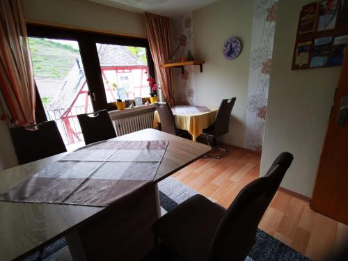 ein Esszimmer mit einem Tisch, Stühlen und einem Fenster in der Unterkunft Gästehaus Andrea Blatt in Bruttig-Fankel