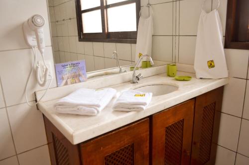 a bathroom with a sink with towels on it at Pousada Maresias do Cumbuco in Cumbuco