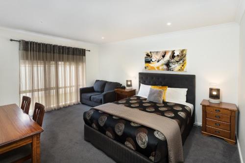 a bedroom with a bed and a couch at Addison Motor Inn in Shepparton