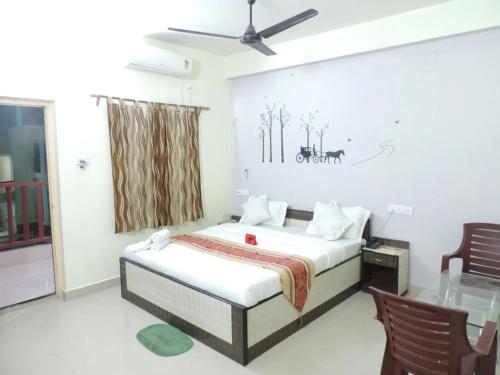 a bedroom with a bed and two chairs and a window at Beach Facing Resort Mandarmani in Mandarmoni
