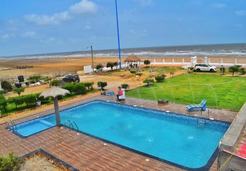 a swimming pool with a view of the beach at Beach Facing Resort Mandarmani in Mandarmoni