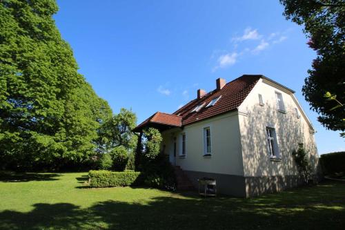 uma pequena casa branca num campo de relva em Ferienhaus Ratteyer Idyll em Schönbeck