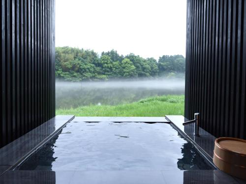 a bathroom with a bath tub with a view of a lake at Kohanyu in Kami