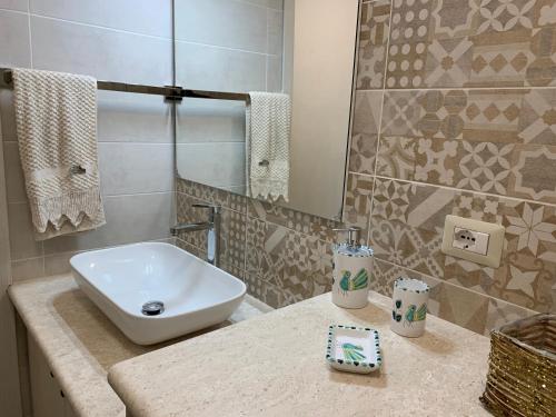 een badkamer met een witte wastafel en een spiegel bij Sa Domo ‘e su Banditore in Orosei
