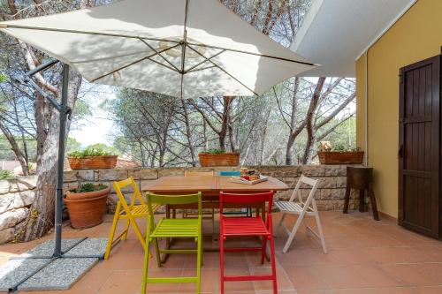 a table and chairs with an umbrella on a patio at Villa Viola in Narbolia