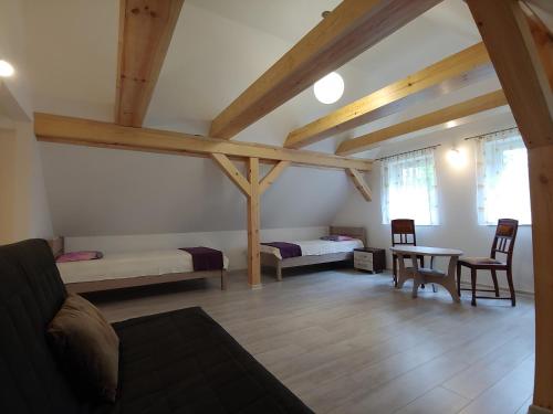 a room with two beds and a table and chairs at Mazurska Perła in Jaśkowo