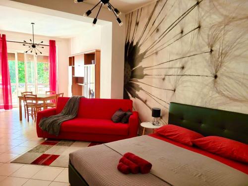 sypialnia z czerwonym łóżkiem i czerwoną kanapą w obiekcie Viale Umberto I Apartments w mieście Sassari