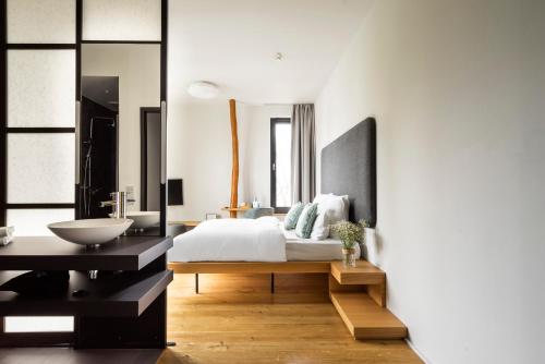 a bedroom with a large bed and a sink at Numa Berlin Drift in Berlin