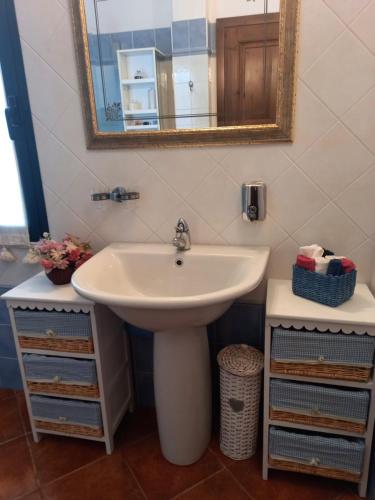 a bathroom with a sink and a mirror at Appartamento in zona residenziale in Orosei