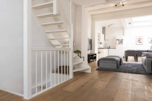 a white living room with a staircase and a living room at Stylish Canalhouse A in Amsterdam