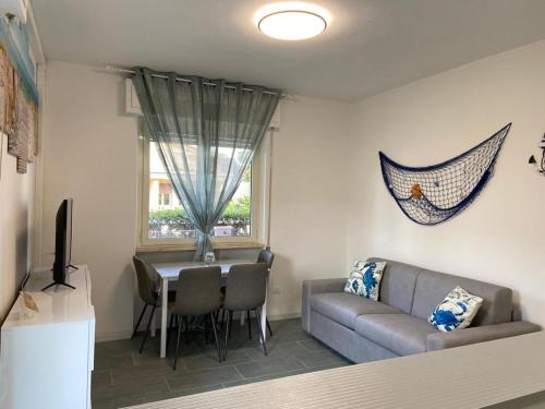 ein Wohnzimmer mit einem Sofa und einem Tisch in der Unterkunft Appartamento completamente rinnovato, con giardino, a 100 mt dal mare in Marina di Massa