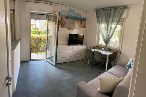 ein Wohnzimmer mit einem Sofa und einem Tisch in der Unterkunft Appartamento completamente rinnovato, con giardino, a 100 mt dal mare in Marina di Massa