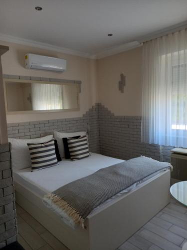 een slaapkamer met een groot wit bed met kussens bij Viola Vendégház in Pápa