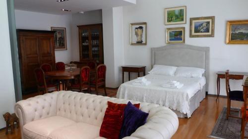 ein Schlafzimmer mit einem Bett, einem Sofa und einem Tisch in der Unterkunft Ma jolie maison by Apulia Accommodation in Bari