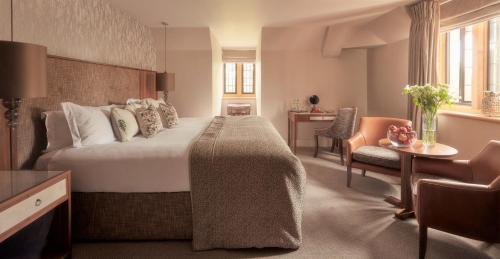 a hotel room with a large bed and a desk at Mallory Court Country House Hotel & Spa in Leamington Spa