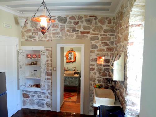eine Küche mit einer Steinmauer und einem Waschbecken in einem Zimmer in der Unterkunft 1836 Traditional House in Vathy