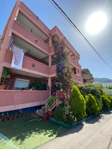 een roze huis met een handdoek aan de zijkant bij Apartments Nikičić in Bar