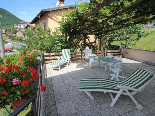 a patio with two chairs and a table and flowers at Apartment Cinzia by Interhome in Vercana