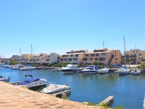 a group of boats docked in a harbor with buildings at Apartment Les Méridiennes by Interhome in Gruissan