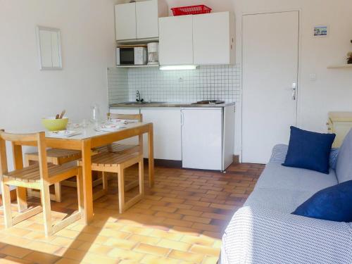 un salon avec une table et une cuisine dans l'établissement Apartment Les Méridiennes by Interhome, à Gruissan