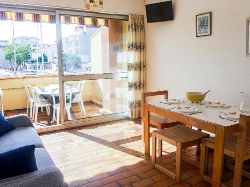 a living room with a table and a dining room at Apartment Les Méridiennes by Interhome in Gruissan