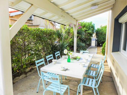 una mesa blanca y sillas en un patio en Holiday Home Les Vives by Interhome, en Narbonne-Plage