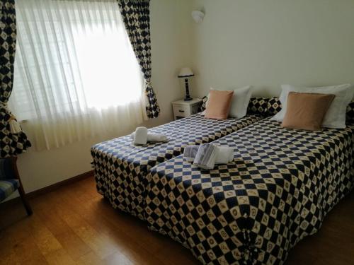 a bedroom with a bed with a checkered blanket at Casa Loureiro - Vista Rio Douro in Resende