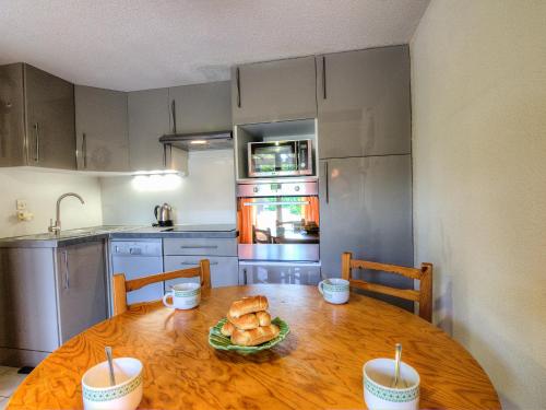 a kitchen with a wooden table with bread on it at Holiday Home Port Sud by Interhome in Saint-Cyprien-Plage