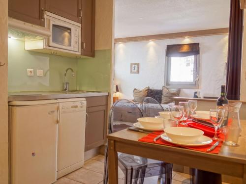a kitchen with a table with plates and wine glasses at Apartment Plein Soleil-3 by Interhome in Tignes