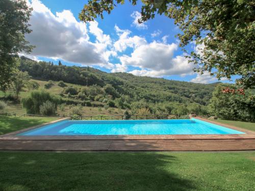 una piscina en un patio con una montaña en el fondo en Holiday Home Torsoli by Interhome, en Lucolena in Chianti