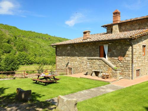 un edificio de piedra con una mesa de picnic en un patio en Holiday Home Torsoli by Interhome en Lucolena in Chianti