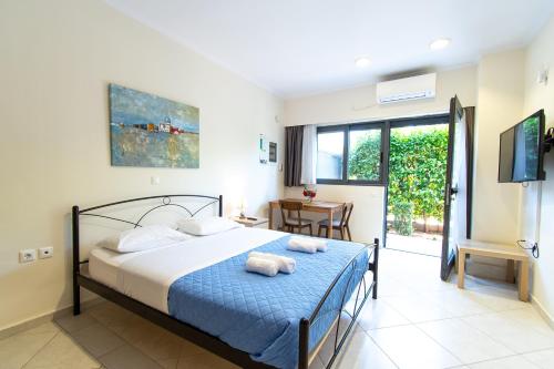a bedroom with a bed with towels on it at Fotis Apartments in Artemida