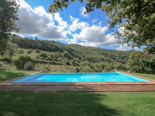 una piscina en un patio con una montaña en el fondo en Holiday Home Lucolena by Interhome, en Lucolena in Chianti