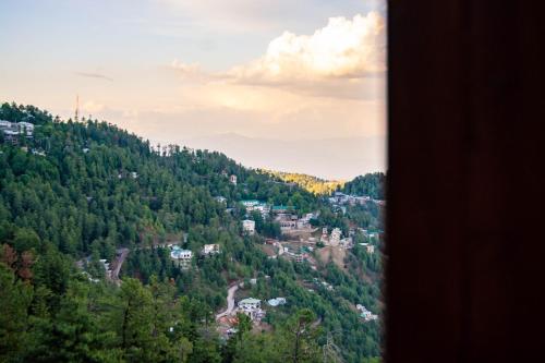 a view of a town in the middle of a mountain at The Roomy Lodge, Murree in Murree