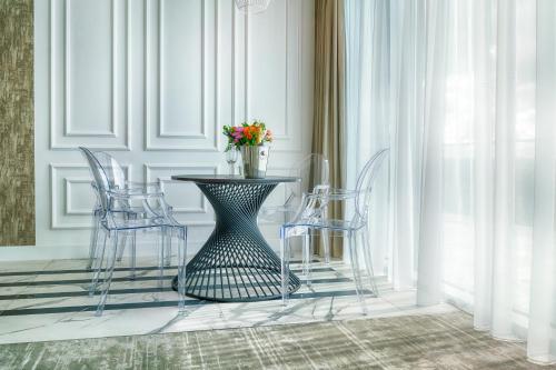 a dining room with a table with chairs and a vase of flowers at Grand Focus Hotel Szczecin in Szczecin