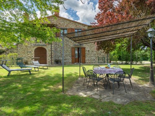 een tafel en stoelen in de tuin van een huis bij Holiday Home Casale il Giglio-1 by Interhome in Ciggiano