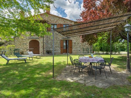 a table and chairs in the yard of a house at Holiday Home Casale il Giglio-1 by Interhome in Ciggiano