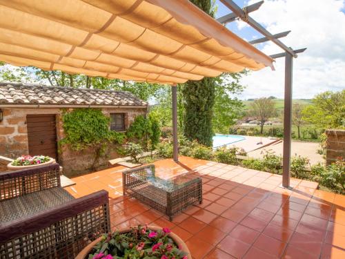 a patio with two chairs and a table and an umbrella at Villa Podere Agnese by Interhome in Centeno