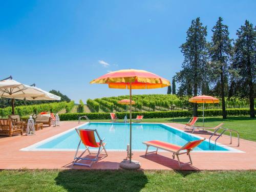 a swimming pool with two chairs and umbrellas at Villa Camporbiano by Interhome in Camporbiano