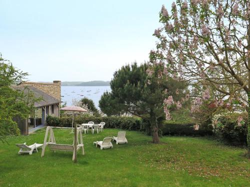 un patio con sillas, mesas y un árbol en Holiday Home Bella Vista by Interhome, en Saint-Suliac