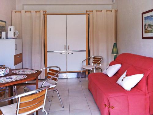 un salon avec un canapé rouge et une table dans l'établissement Apartment Bleu Marine by Interhome, à Lancieux