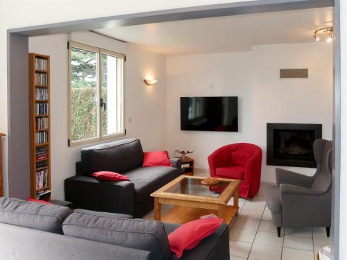 un salon avec un canapé, des chaises et une télévision dans l'établissement Holiday Home Le Cèdre Bleu by Interhome, à Plérin
