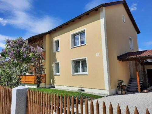 a house with a fence in front of it at Ferienwohnung Seenglück in Wackersdorf