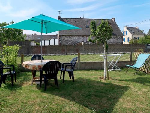 プレヌフ・ヴァル・アンドレにあるHoliday Home La Corvette - PFE106 by Interhomeの庭にテーブルと椅子、青い傘