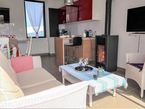 een woonkamer met een tafel en een open haard bij Holiday Home Ty Angèle - PLC239 by Interhome in Plouescat
