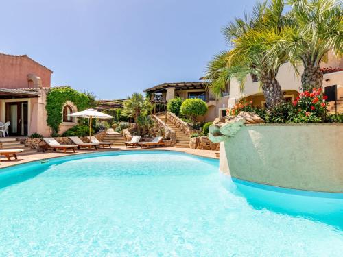 - une piscine dans une cour avec des chaises et des palmiers dans l'établissement Holiday Home Bougainville 6 - Vista Village by Interhome, à Porto San Paolo