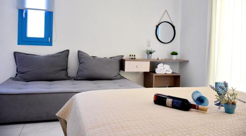 a bedroom with a bed with a bottle of wine on it at The Blue Rooms in Áyioi Apóstoloi