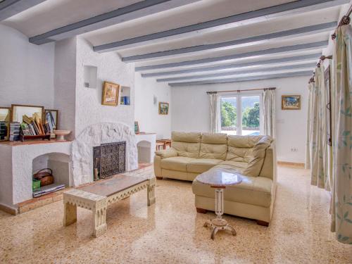 a living room with a couch and a fireplace at Holiday Home Forest by Interhome in Benitachell
